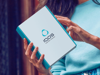 Woman opening an IQOS box delivered to her home