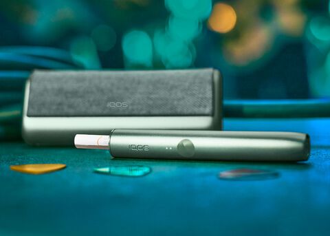 جهاز وشاحن IQOS ILUMA باللون الأخضر.