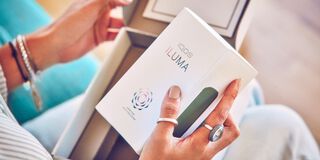 A person holding an unopened IQOS device box.