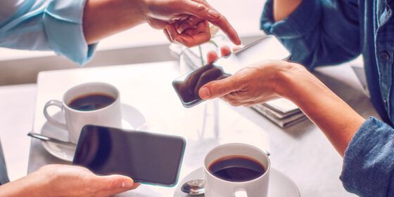 Two people with mobile phones having coffee.