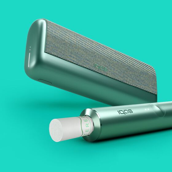 أنبوب تسخين IQOS ILUMA PRIME أخضر وجهاز مطابق له مع لفافة التبغ المسخّن TEREA داخله.
