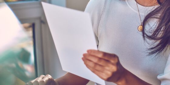 A person holding a sheet of paper.