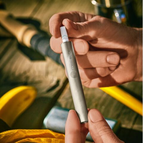 شخص بيده جهاز IQOS ILUMA