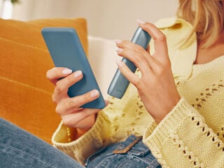 يدان تمسكان هاتفاً محمولاً وجهاز IQOS Originals One لتنزيل التطبيق، وذلك للحصول على صيانة محترفة كاملة.