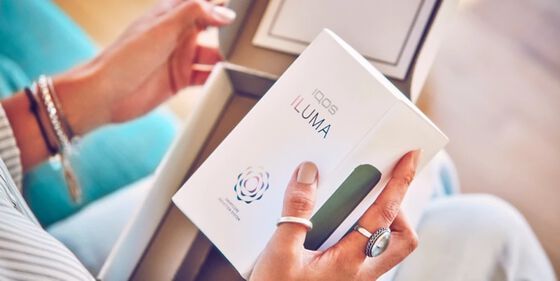 Hands unboxing an IQOS ILUMA.