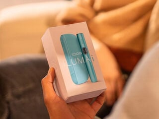 One person handing an IQOS device box to a smiling woman.