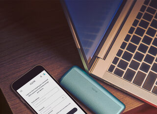 A man sitting on a couch looking at a laptop.