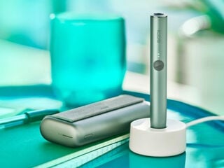 Two people holding phones over two cups of coffee.