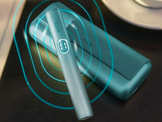 Hands holding an unopened IQOS device box.