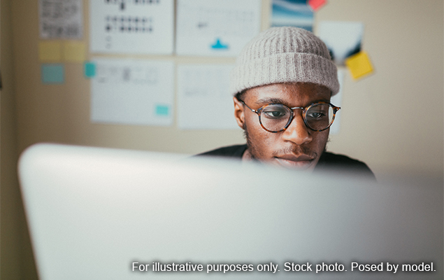 رجل ينظر إلى كمبيوتر محمول