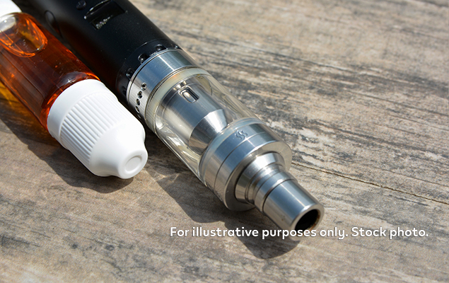 Vape next to bottle of e-liquid